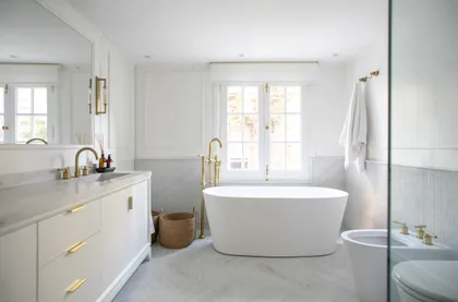 Baño moderno y luminoso con bañera exenta y detalles dorados — proyecto ARROYO, por Parq Estudio, en Buenos Aires